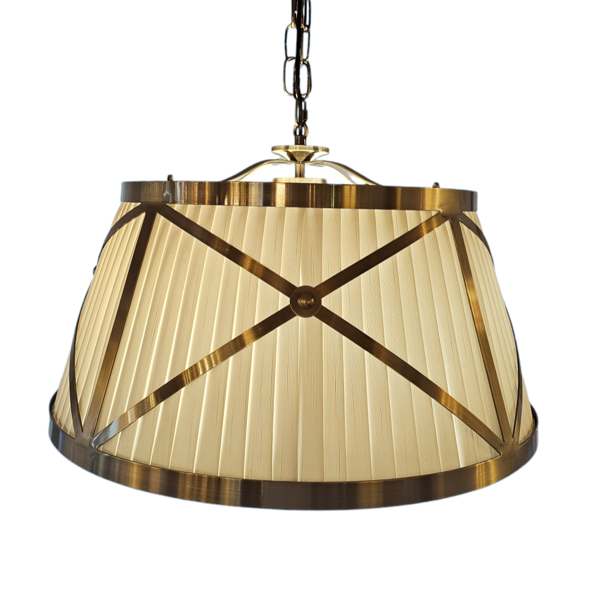 Small 40cm Hanging Pleated Fabric Shade with Antique Brass Metal Criss Cross Frame.&nbsp;This light is a hanging frame defined by its striking criss-cross design. It features an inner pleated white lampshade which is open from the bottom. (Please note: the light globe is intended to be in view when looking up from underneath the shade).
The circular frame with crossed banding is set in four panels, each with it's central finial detail in Antique Brass Metal-ware.